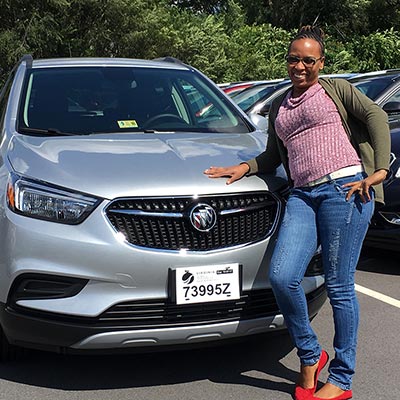 an Avant registered nurse in front of her new car