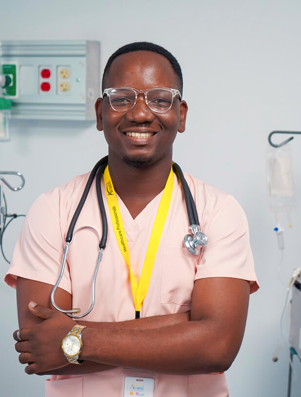 A smiling male healthcare professional in pink scrubs with a stethoscope around his neck, standing confidently in a medical