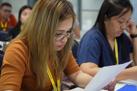 International candidates focus intently on reading documents during the step 4 assessment.