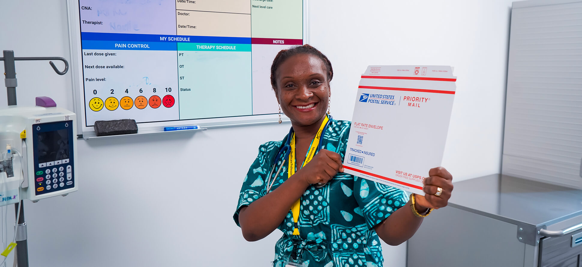 Annastecia Onyinye Avant-Okunoye smiles while holding a USPS priority mail envelope in a medical setting.