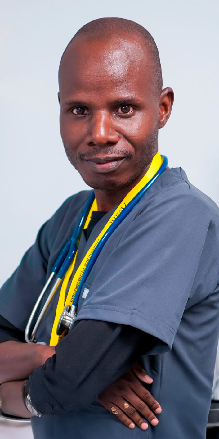 A healthcare professional with a stethoscope around his neck, wearing gray scrubs and confidently crossing his arms.