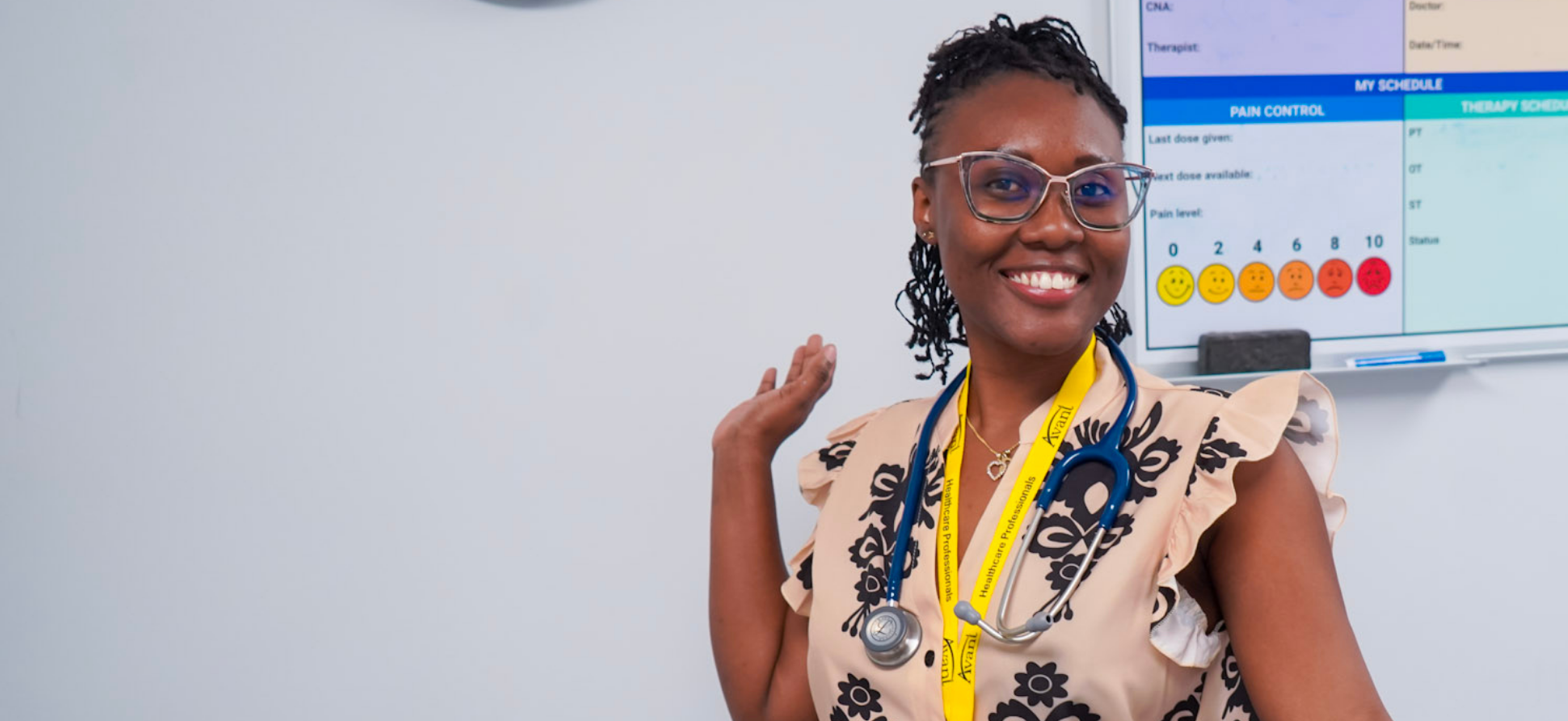 A smiling healthcare professional with a stethoscope around her neck, standing in front of a medical chart.