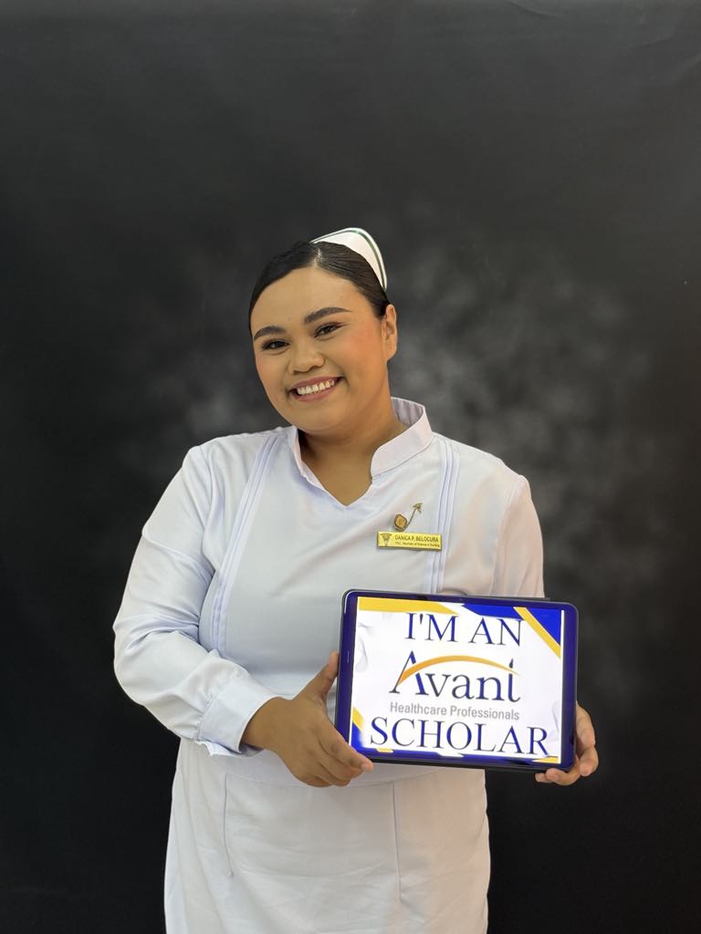 A smiling nurse in white uniform holding a tablet that reads "I'm an Avani Healthcare Professionals Scholar" against a dark