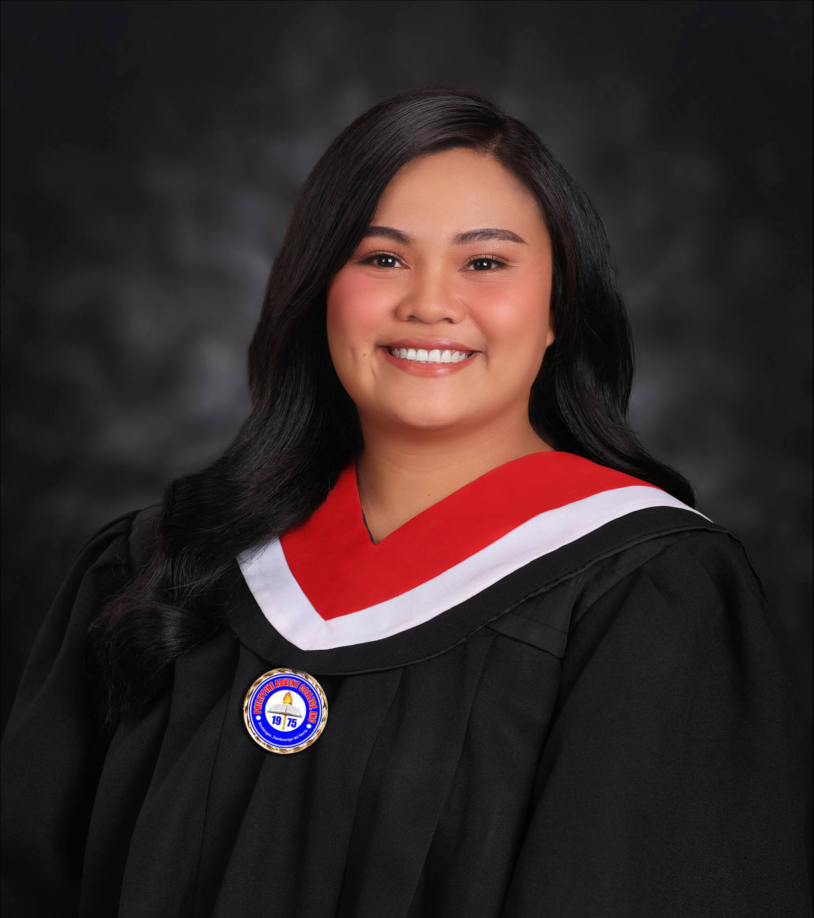 A smiling woman in a graduation gown with a red, white, and black stole and a Philippine Advent College badge.
