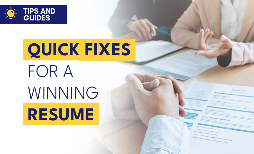 A person holding hands in a professional interview setting with resumes and documents on the table.